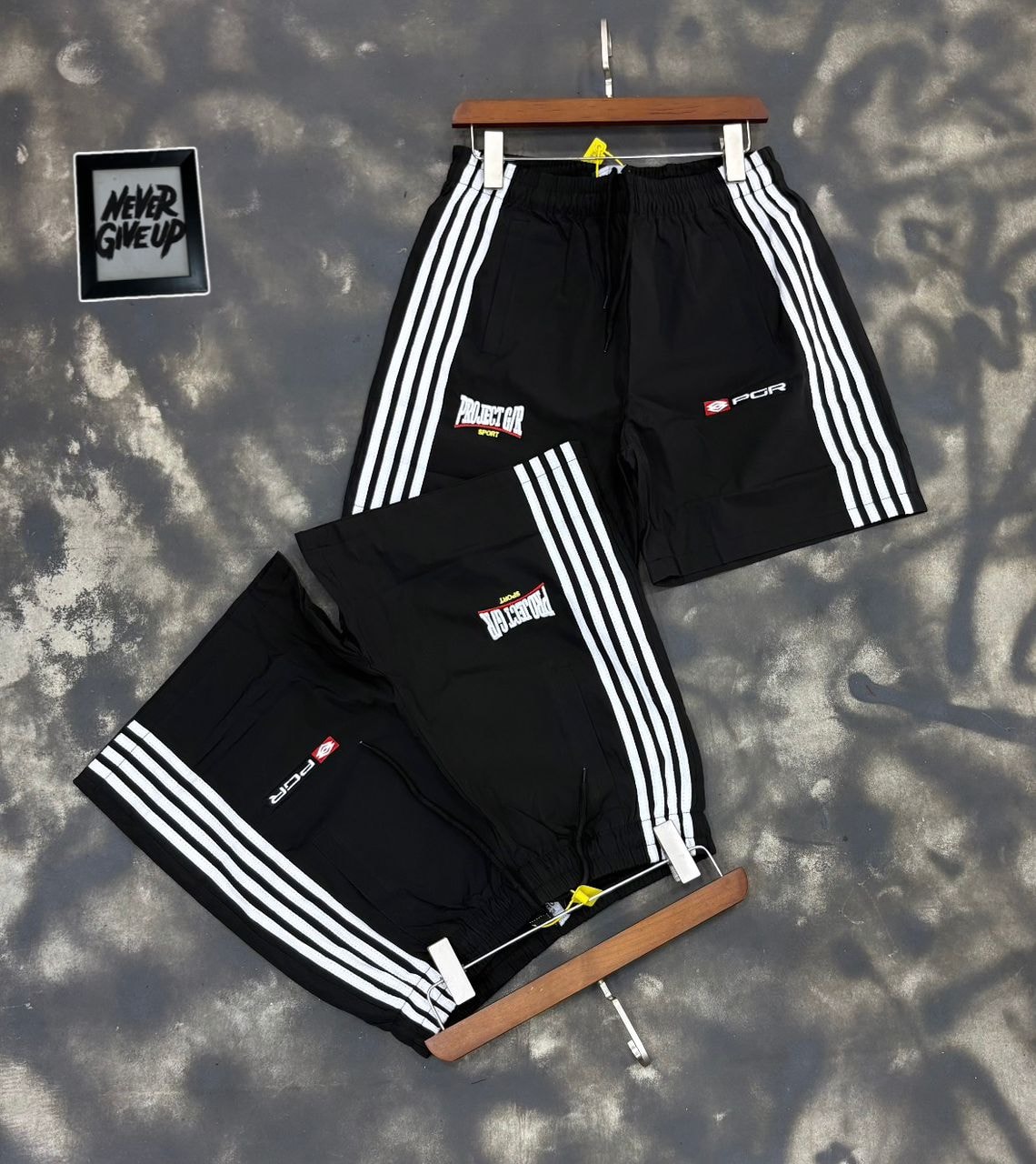Black Projector Sport striped shorts on hanger and flat lay.