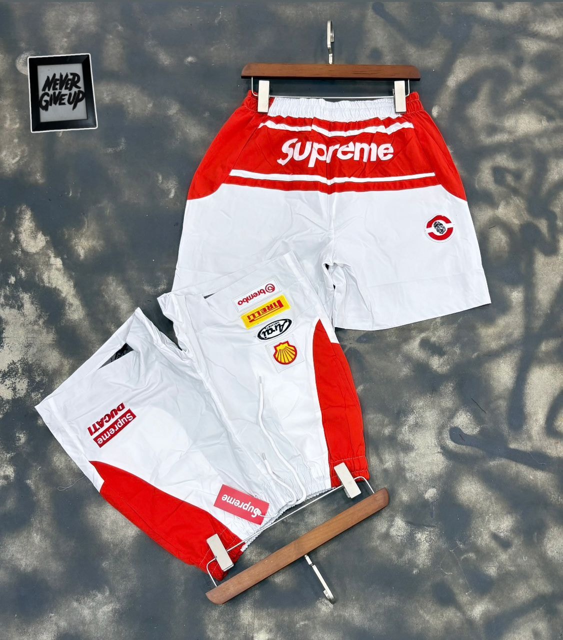 Supreme patch shorts in red and white on hanger and flat lay with logos.