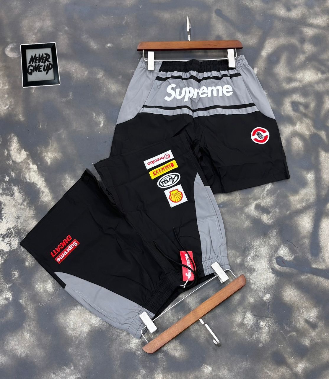Supreme patch shorts in gray and black on hanger and flat lay with patches.