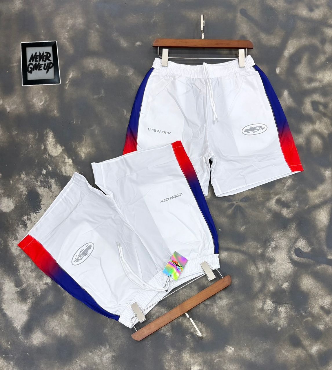 White Litework gradient track shorts on hanger and flat lay.