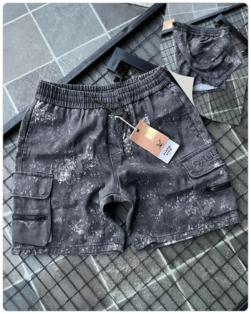 Flat lay of gray splatter dye cargo shorts showing tag and embroidery.