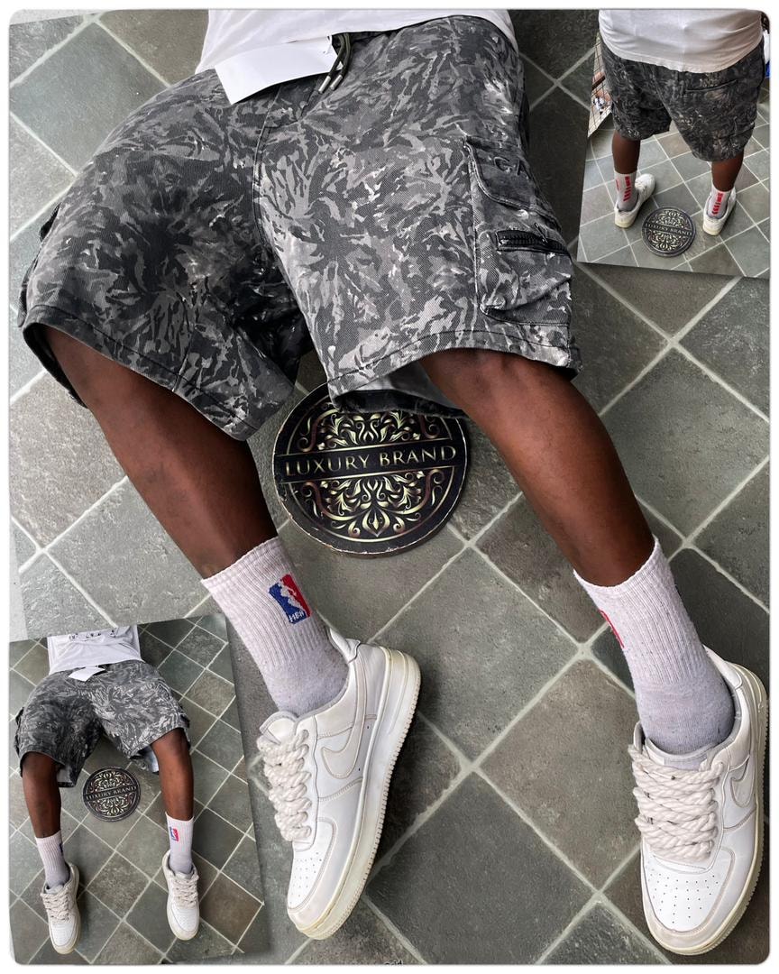 Person modeling gray reptile print cargo shorts paired with white top and sneakers.