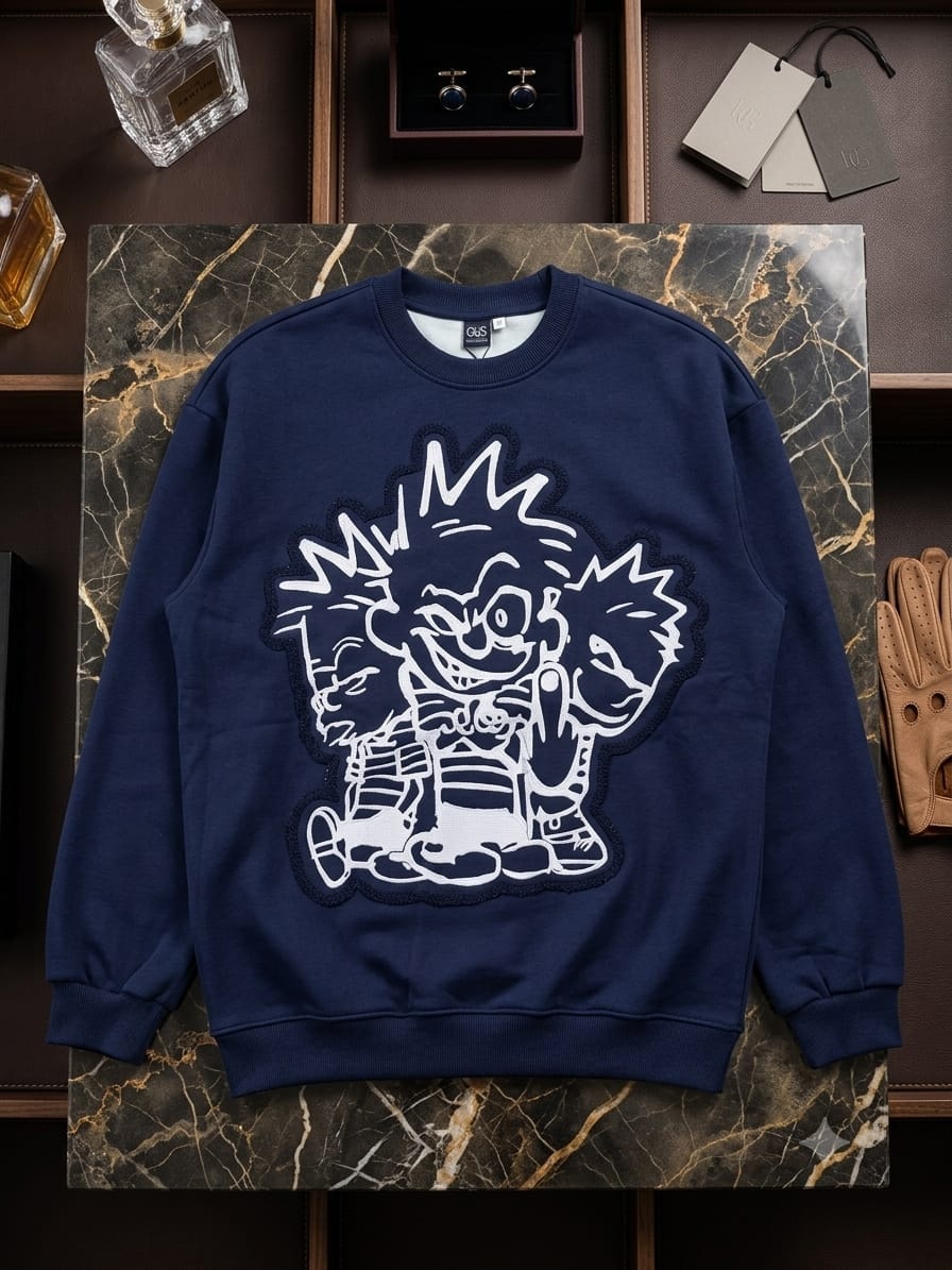 Navy blue sweatshirt with white cartoon character graphic on marble shelf with accessories.