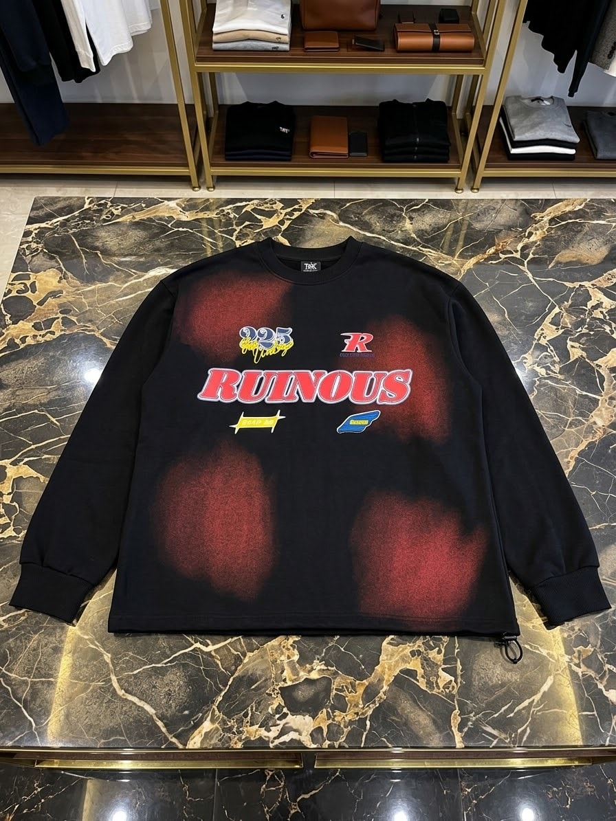 Black sweatshirt with Ruinous red text and graphics laid on marble floor.