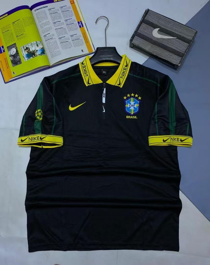 Black Nike Brazil football jersey on hanger with book and box.