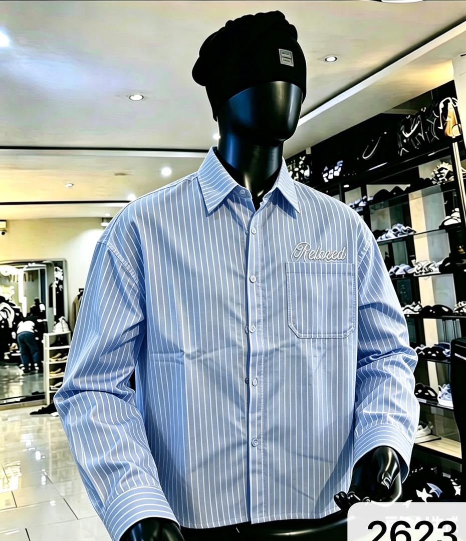 Front view of light blue striped shirt with Relaxed chest embroidery on mannequin.