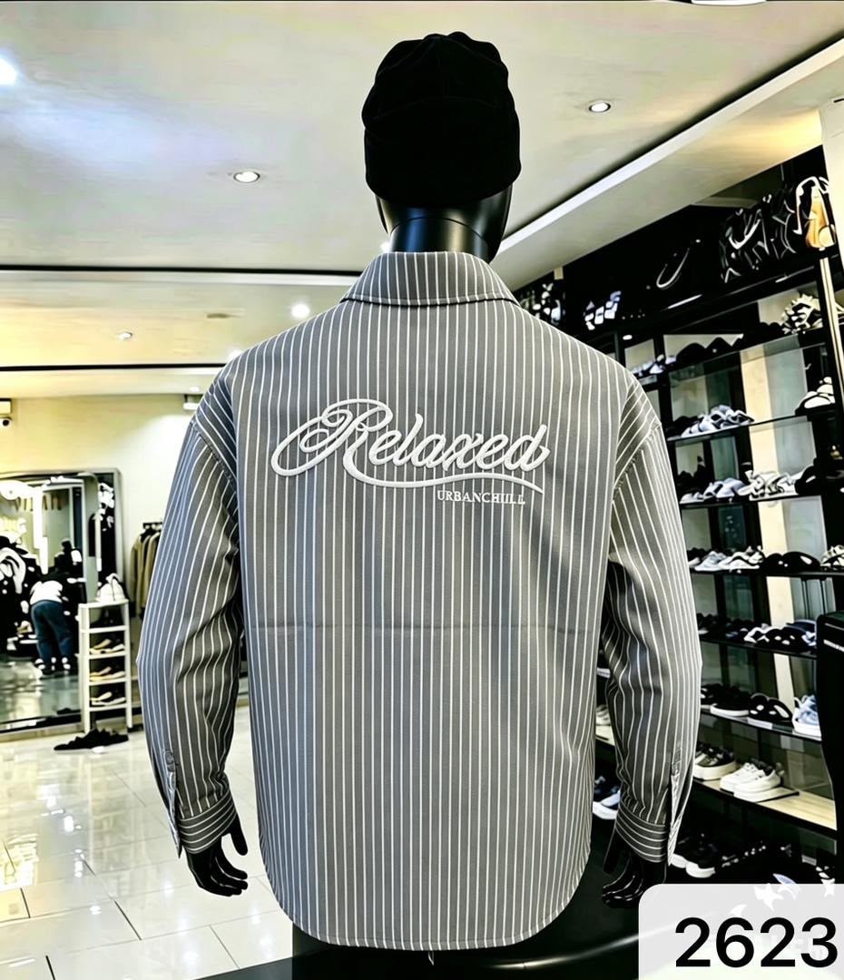 Back view of gray striped shirt with large white Relaxed URBANCHILL embroidery.