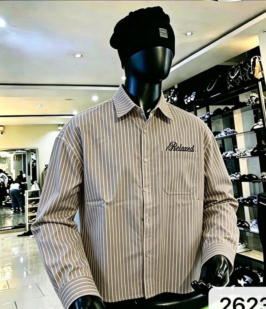 Front view of beige striped button-down shirt with Relaxed chest embroidery on mannequin.