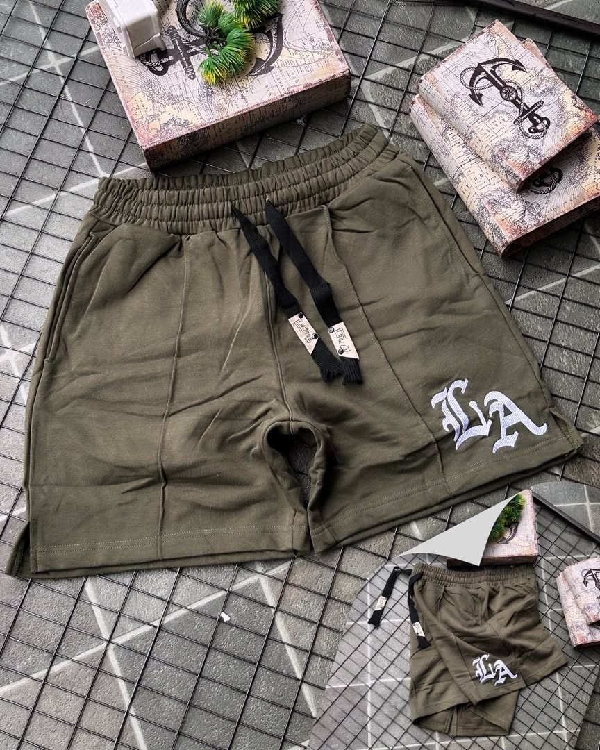 Olive LA embroidered fleece shorts with white logo on grid background.