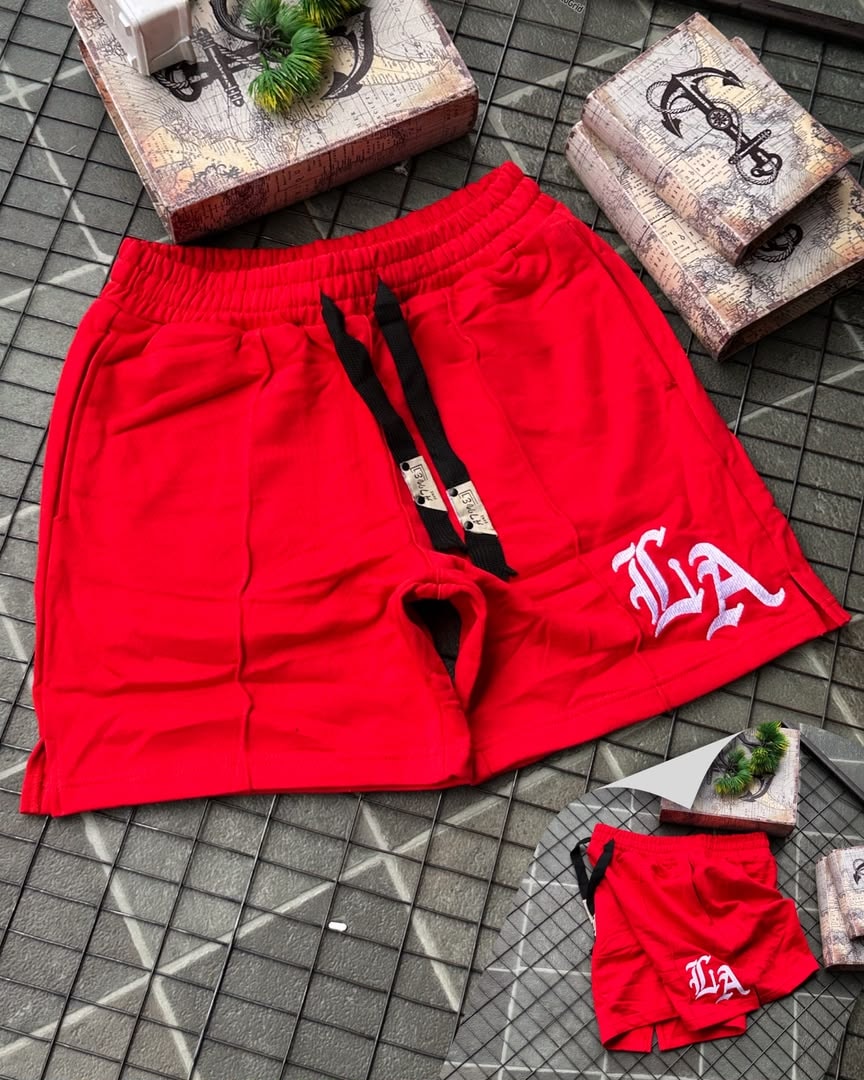 Red LA embroidered fleece shorts with black drawstrings and tags.