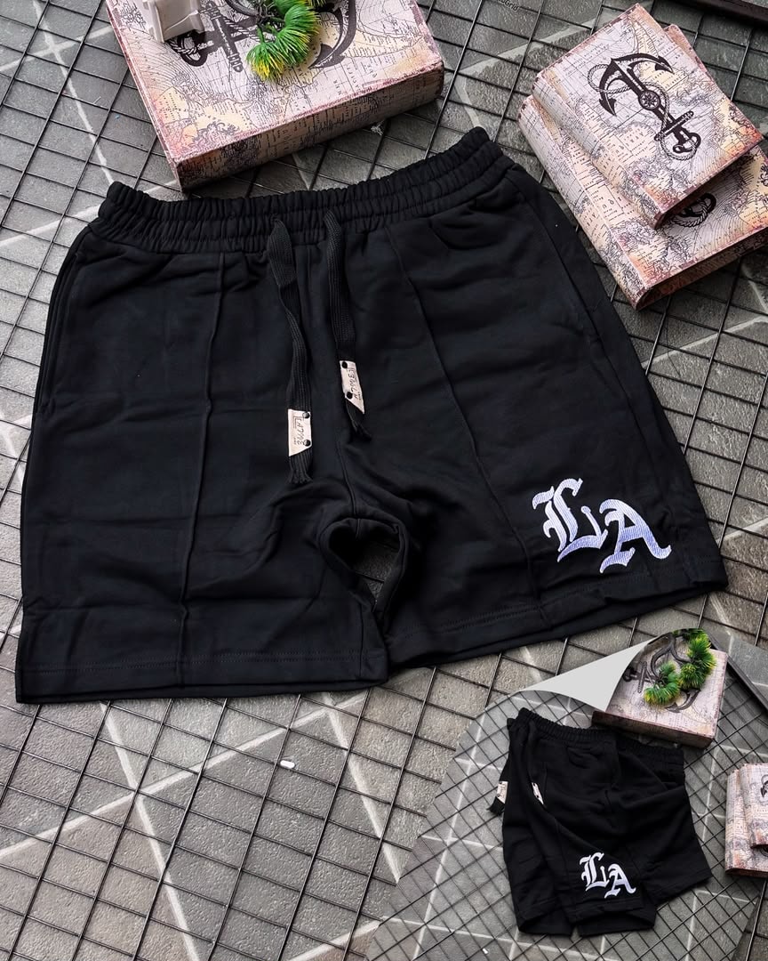 Black LA embroidered fleece shorts with drawstring, tags, and smaller matching pair.