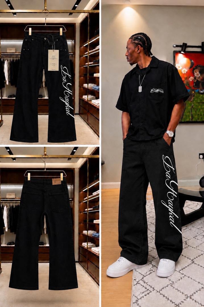 Black baggy jeans with white cursive side print, shown hanging front/back and worn by model.