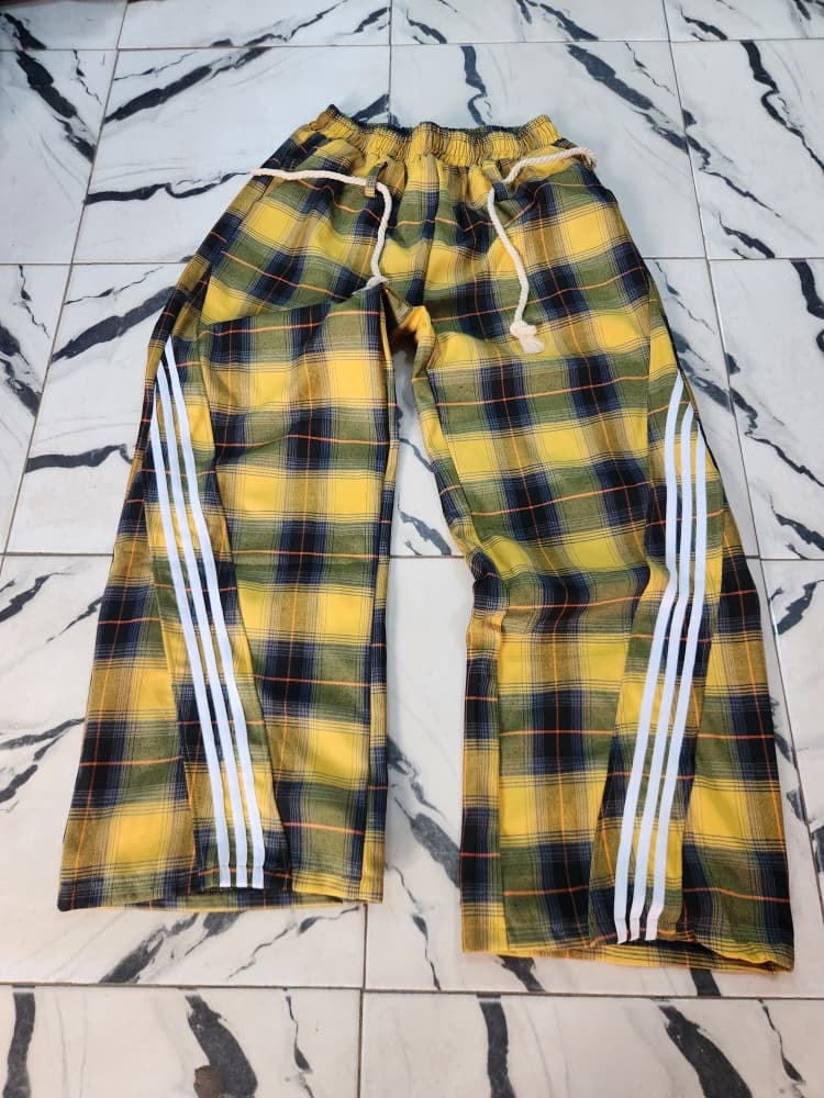 Yellow plaid joggers with white side stripes laid flat.