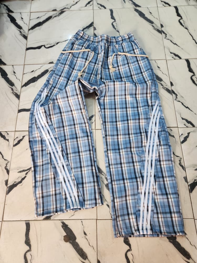 Blue plaid joggers with white side stripes laid flat.