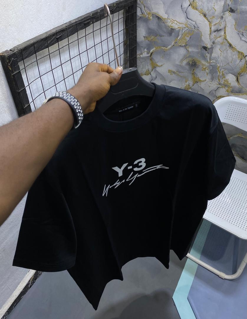 Black t-shirt with Y-3 and signature print held on hanger.