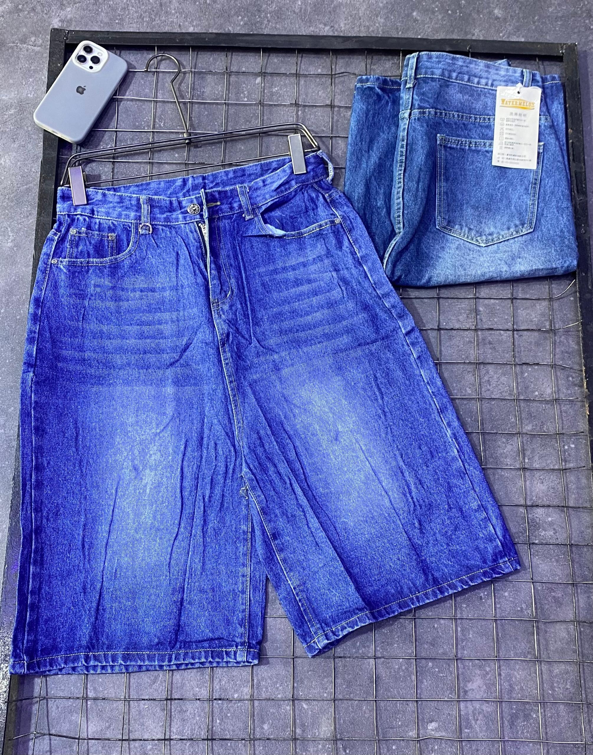 Light blue denim jorts displayed on hanger with folded back view and visible brand tag.