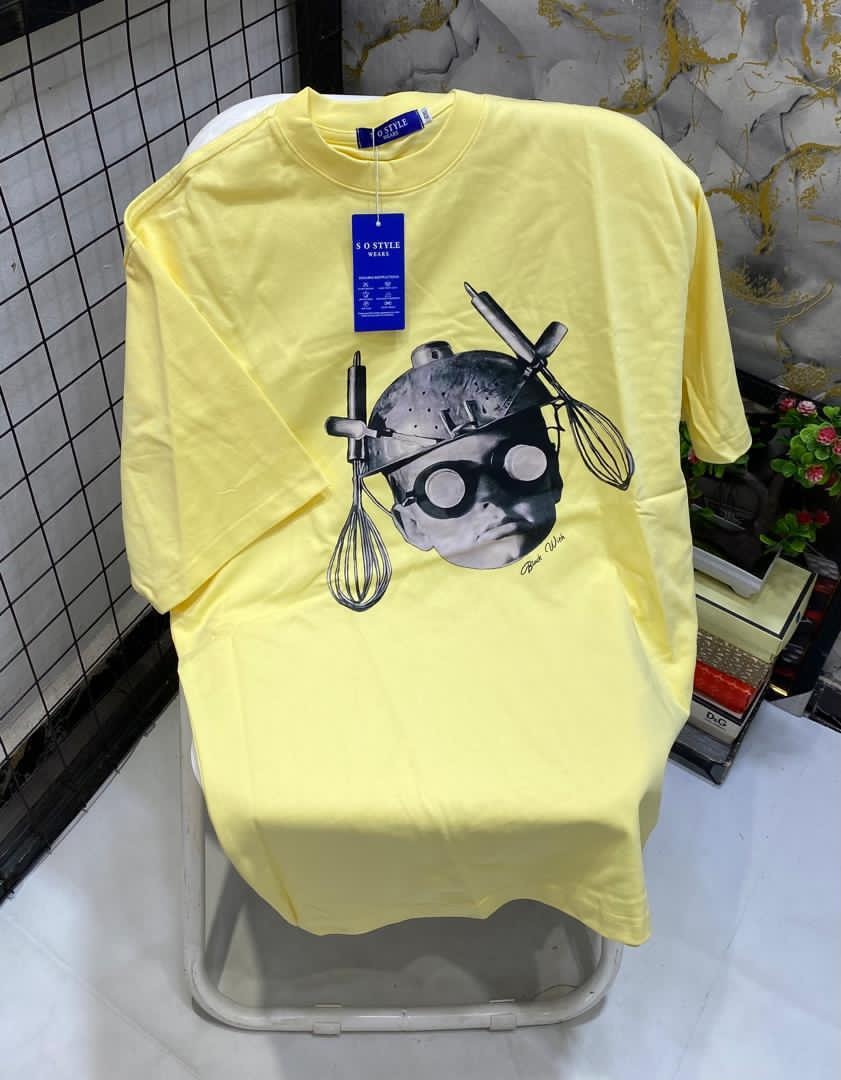 Yellow t-shirt displaying chef portrait graphic composed of kitchen utensils.