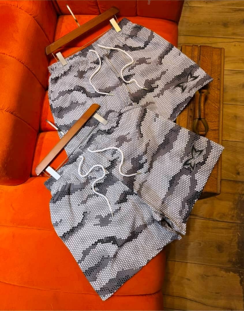 Gray NIKA perforated pattern shorts on wooden hangers.