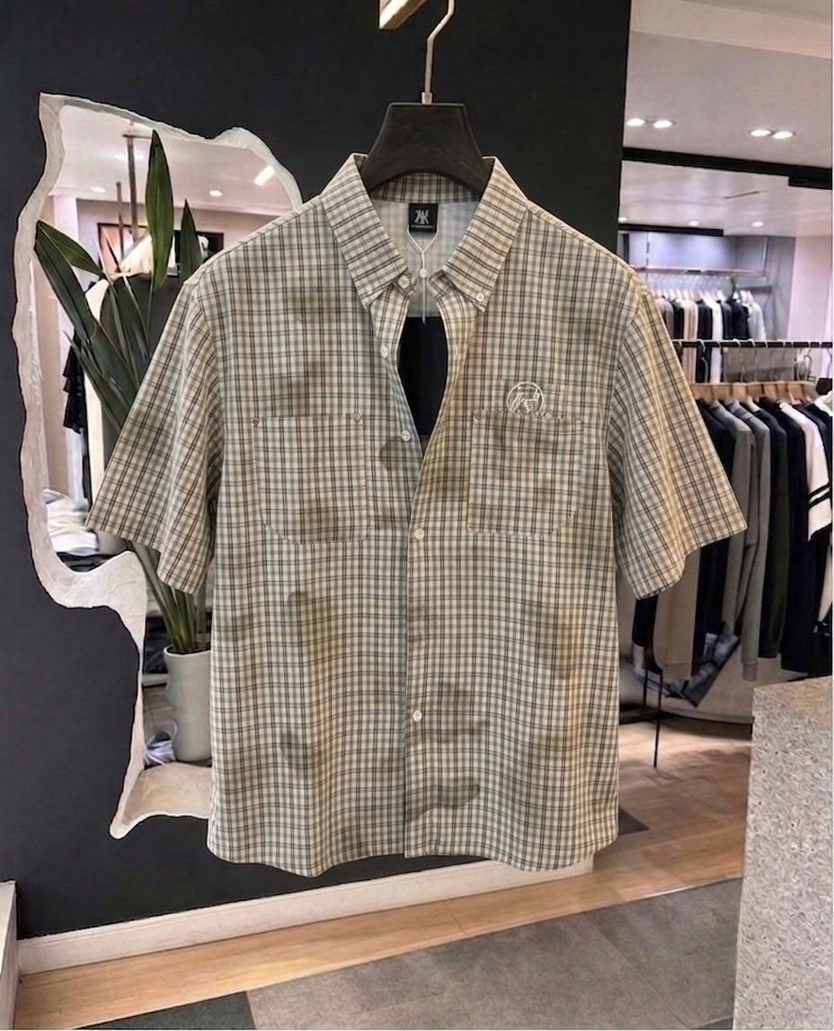 Front view of beige plaid short sleeve button-up shirt with collar, buttons and chest pockets.