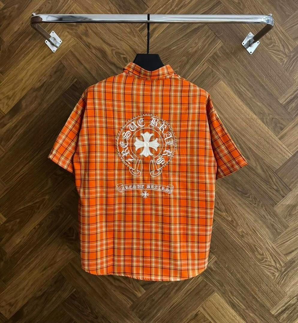Back view of orange plaid shirt displaying large circular embroidery design.