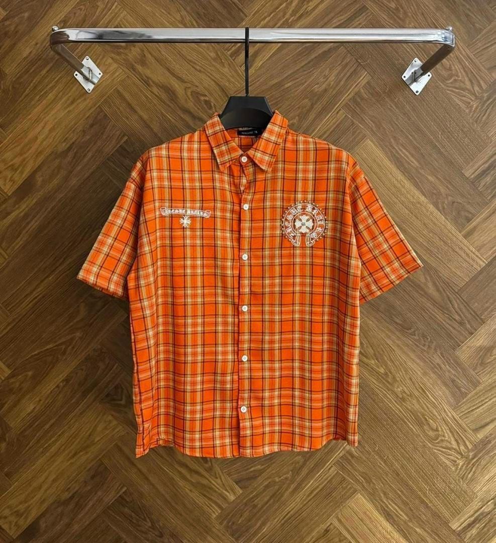 Front view of orange plaid short sleeve button-down shirt with chest embroidery.