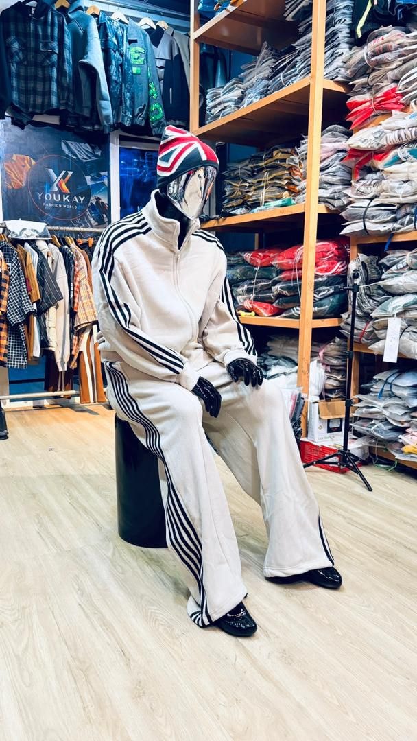 Mannequin in cream velour zip-up tracksuit with black stripes, front view.