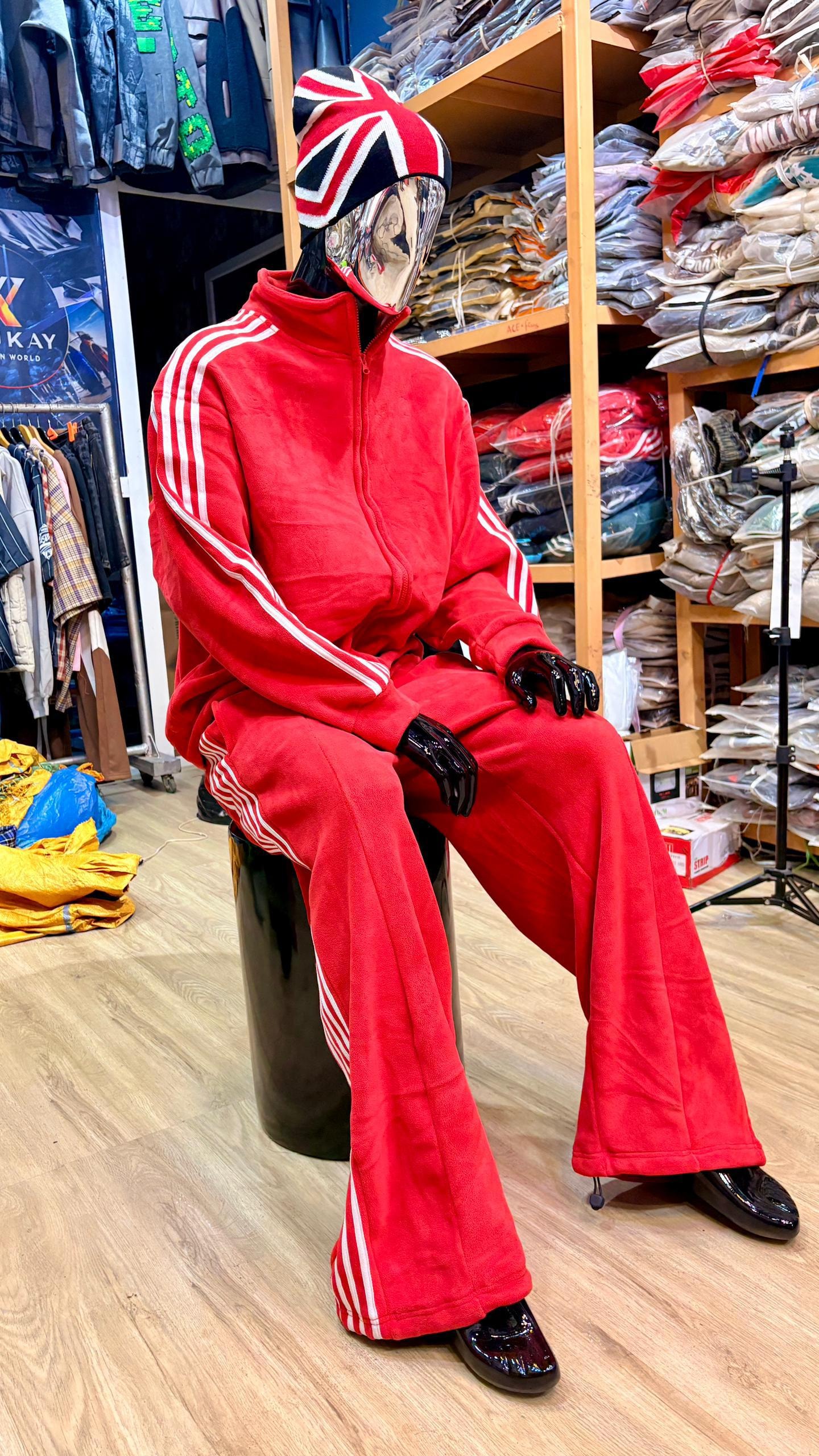 Mannequin in red velour zip-up tracksuit with white stripes and flared pants.
