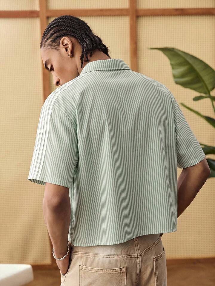 Back view of model in green striped cropped shirt showing shoulder stripes.