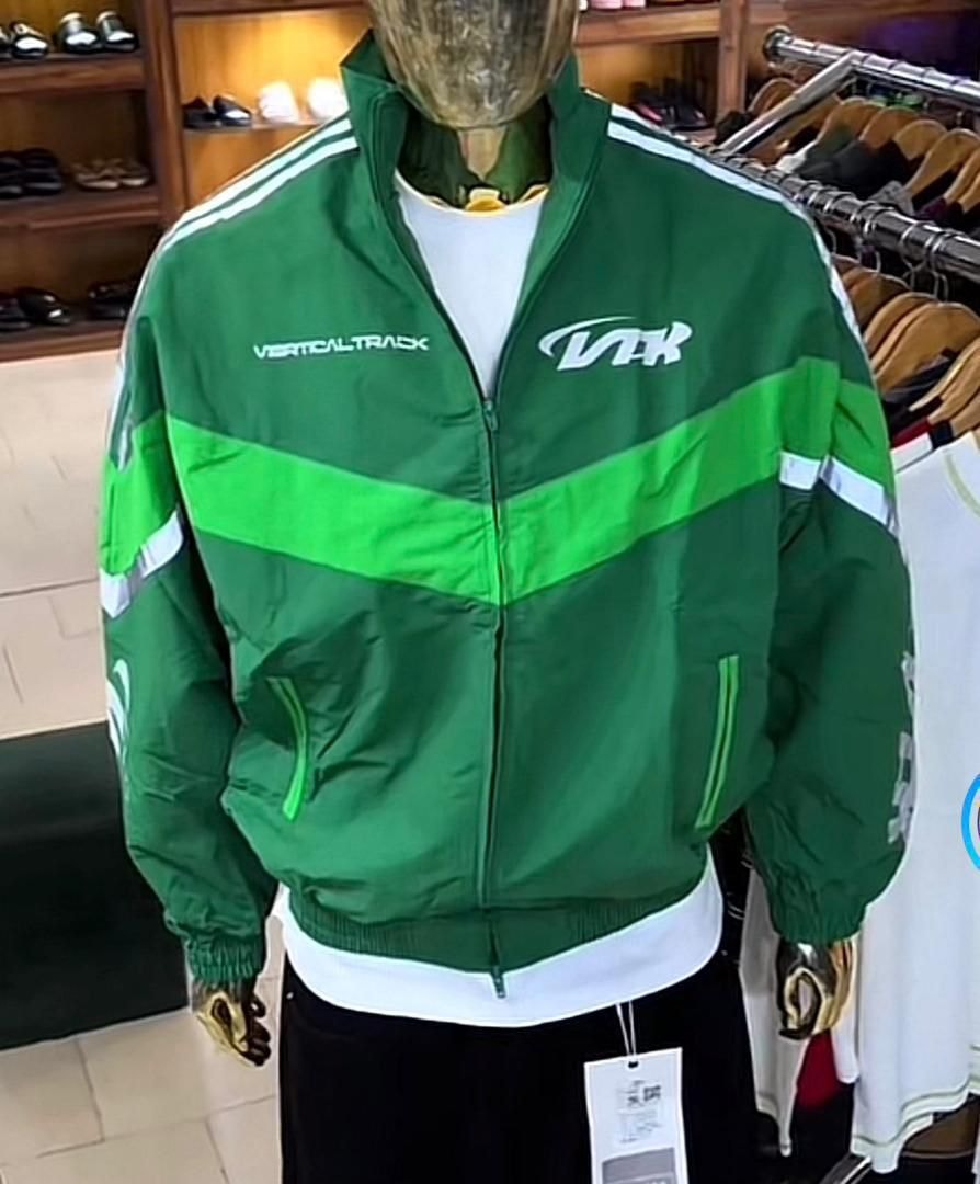 Green VTK track jacket on mannequin in retail store.