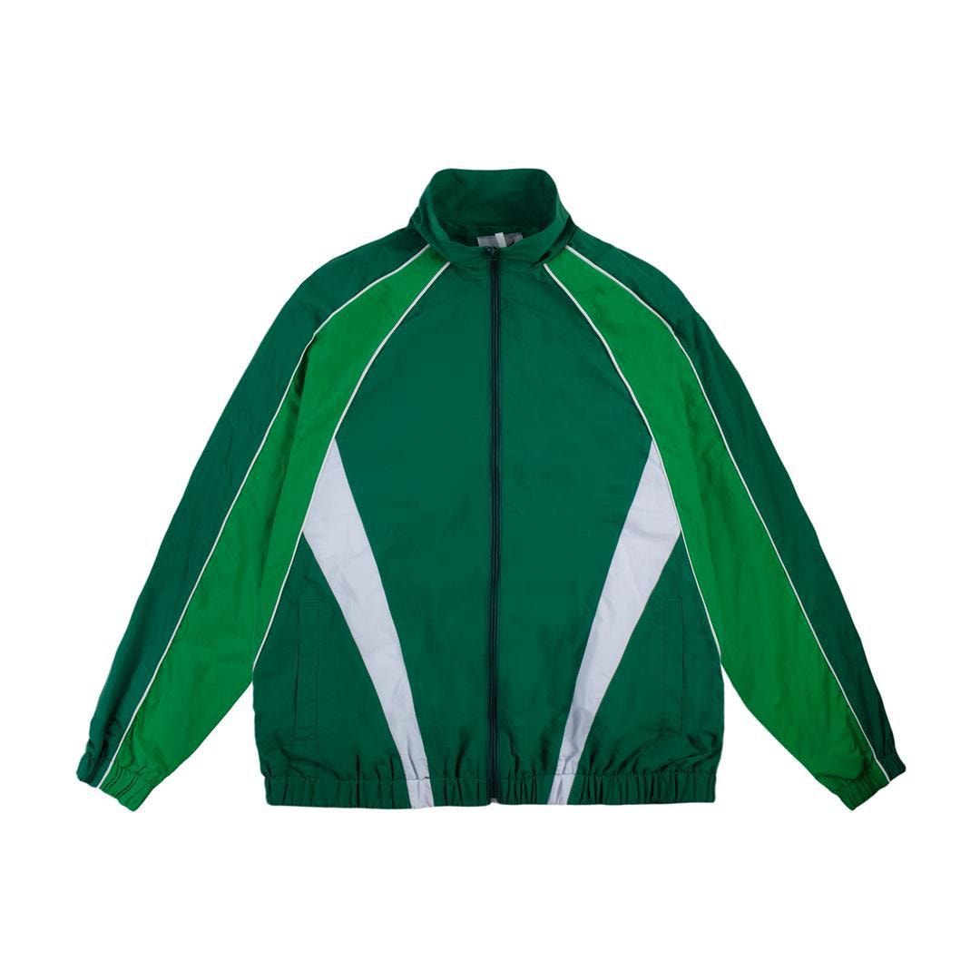 Green panelled track jacket front view on white background.