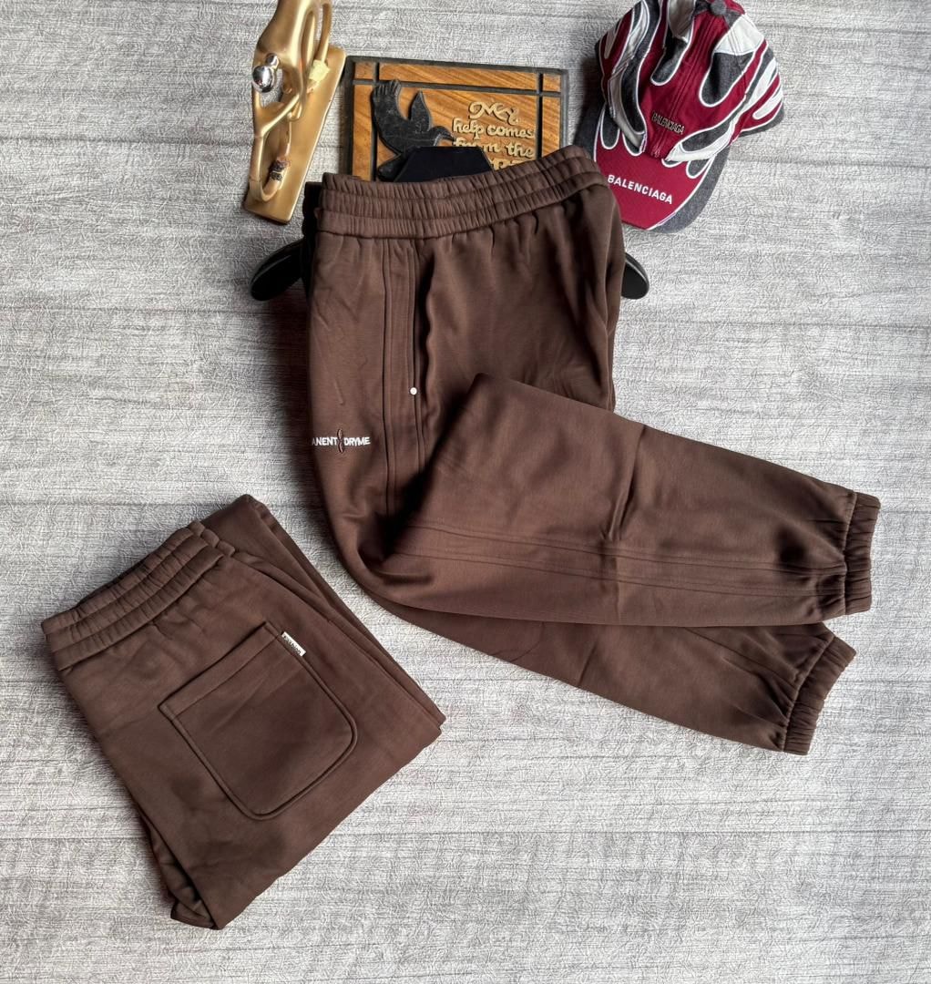 Brown joggers with text logo on thigh, presented in flat lay and folded views.