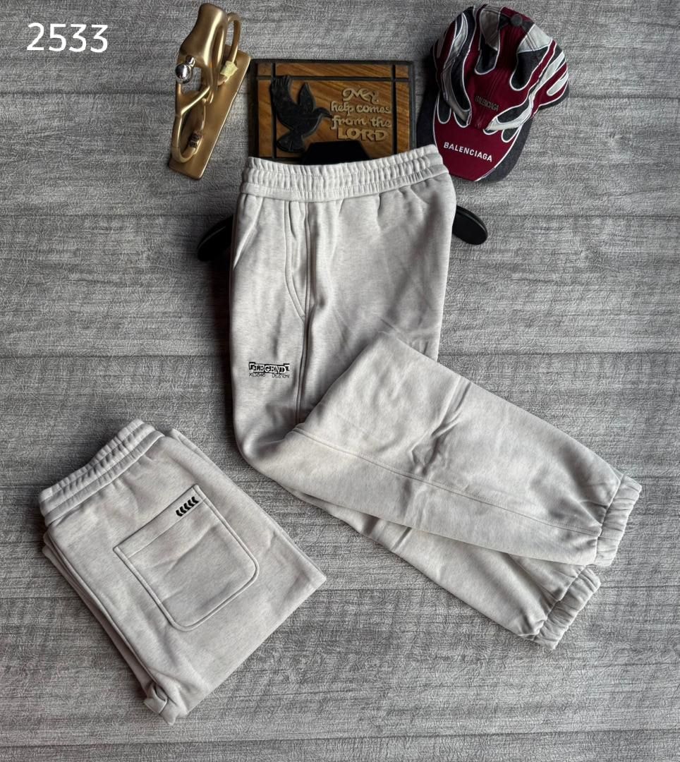Cream joggers with Parachute branding, displayed laid out and folded on textured background.