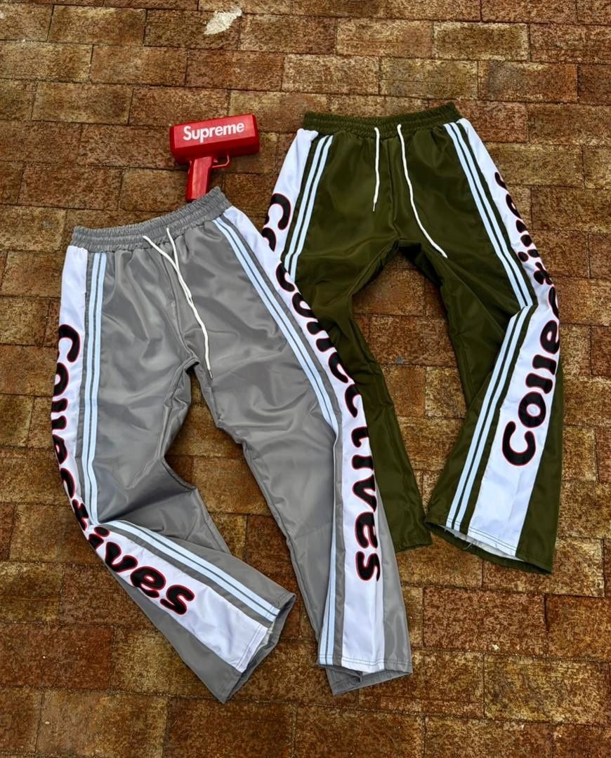 Grey and olive green joggers with white side panels featuring Collectives text and stripes laid on brick floor.