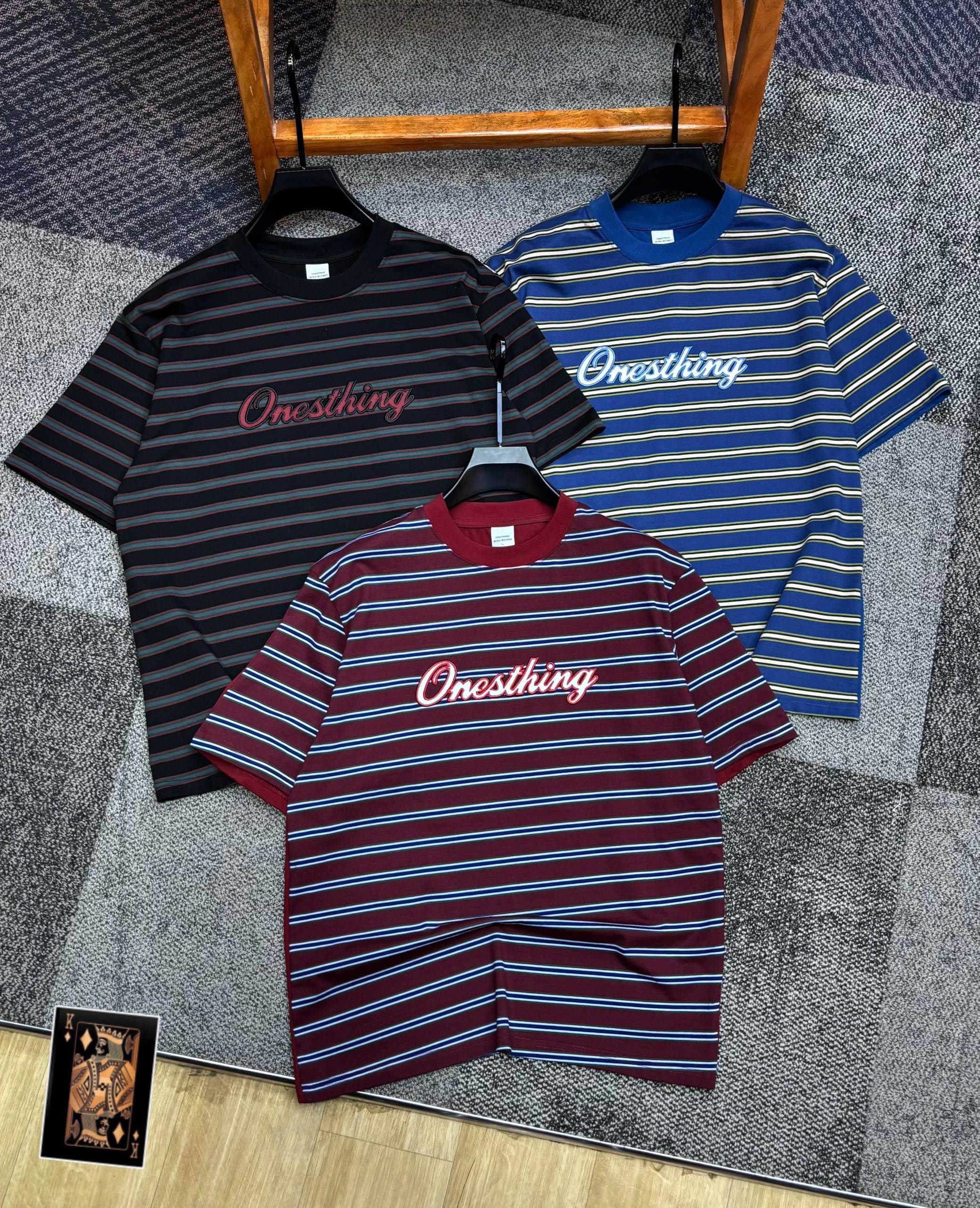 Three striped t-shirts with Onesthing embroidery in black, blue, and burgundy colorways.