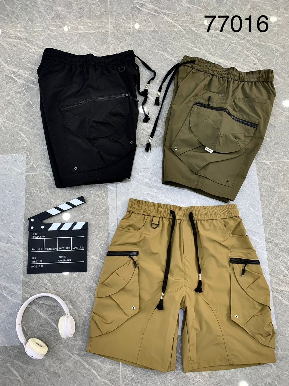 Black, olive, and tan combat cargo shorts in 77016 style with props.