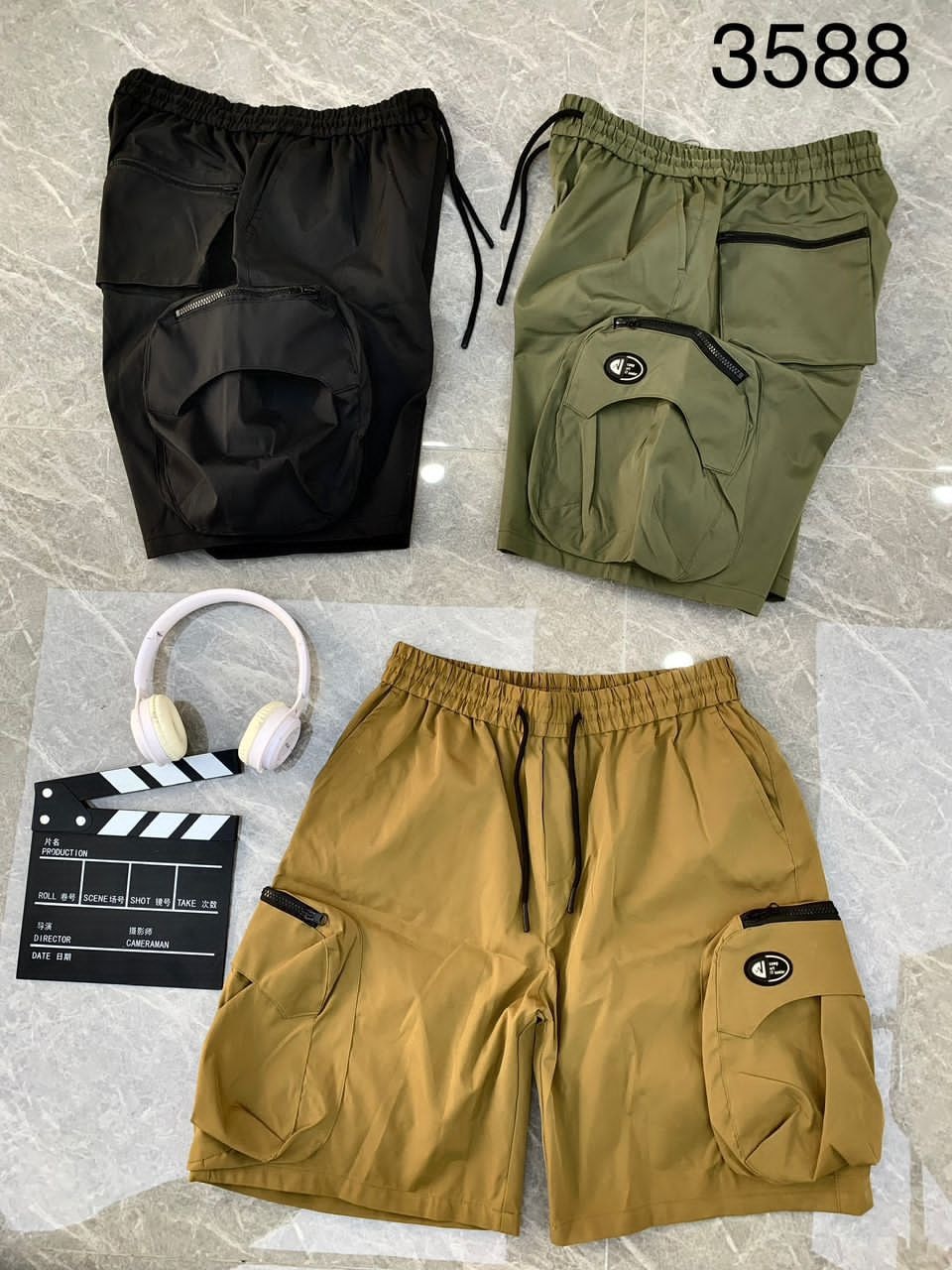 Black, olive, and tan combat cargo shorts in 3588 style with props.
