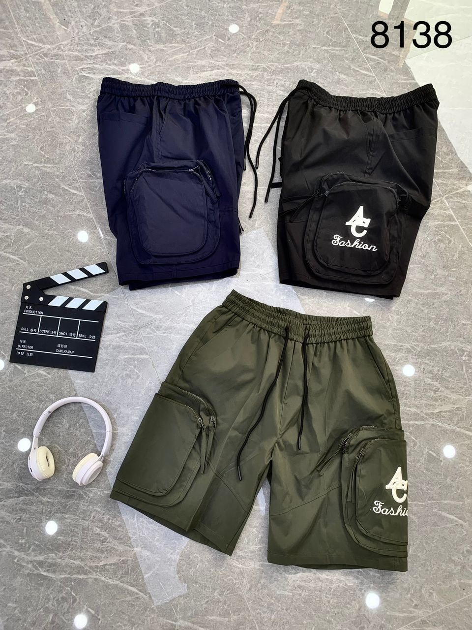 Brown, black, and olive combat cargo shorts with AC Fashion print and clapperboard.