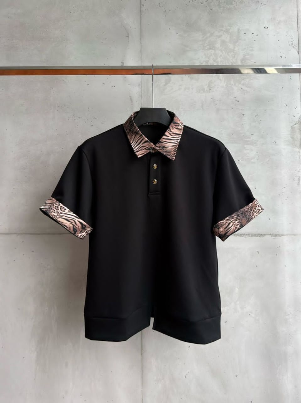 Black short-sleeve polo shirt with animal print collar and cuffs.