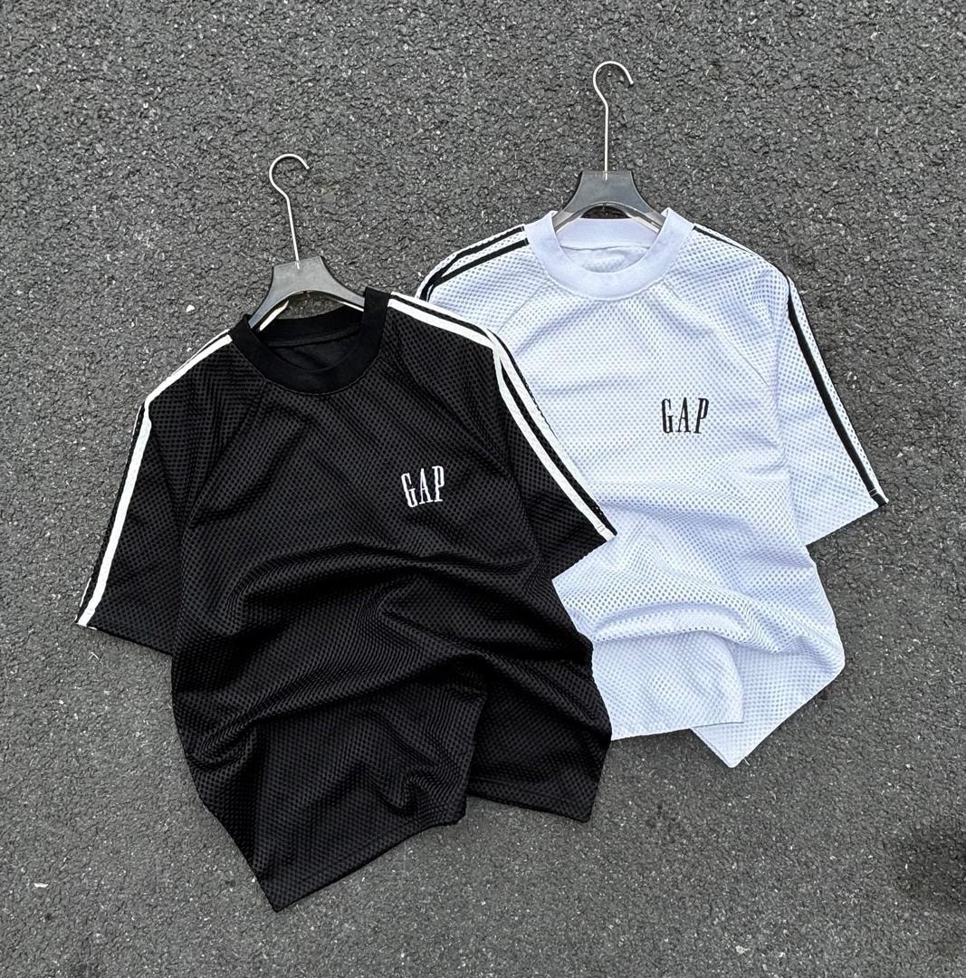 Black and white GAP net mesh polo shirts with striped sleeves on pavement.