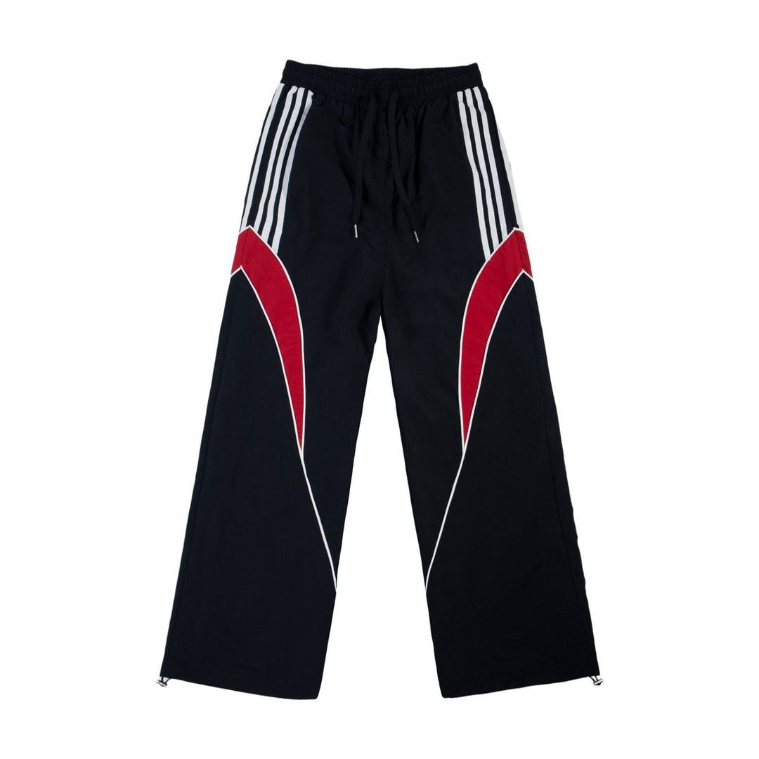 Black track pants with white stripes and red side panels.