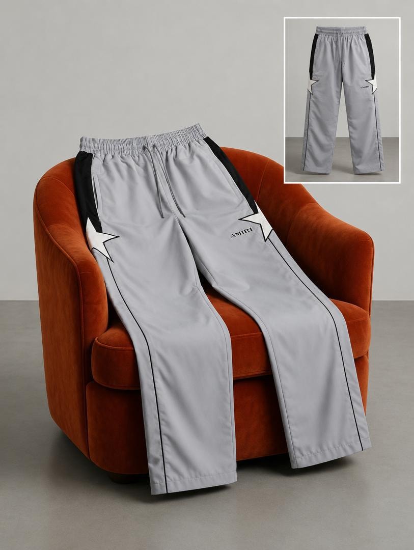 Gray AMIRI star logo joggers on orange chair with inset view.