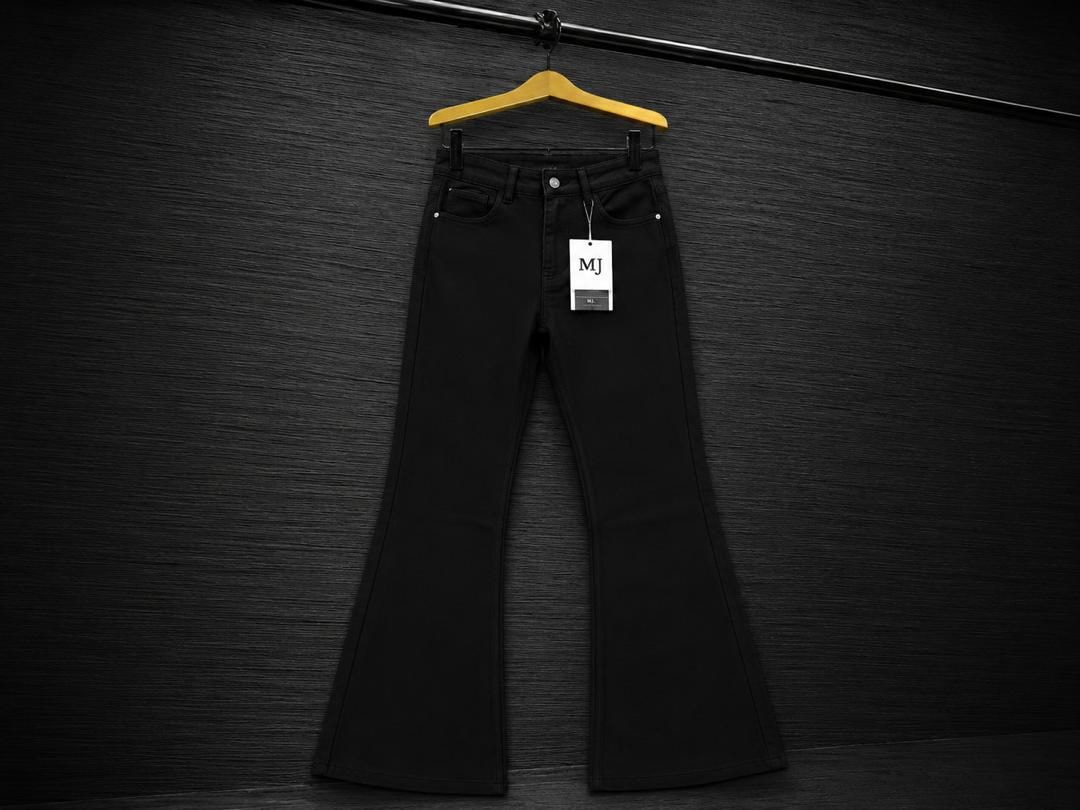 Black flared jeans with MJ tag on wooden hanger against dark background.