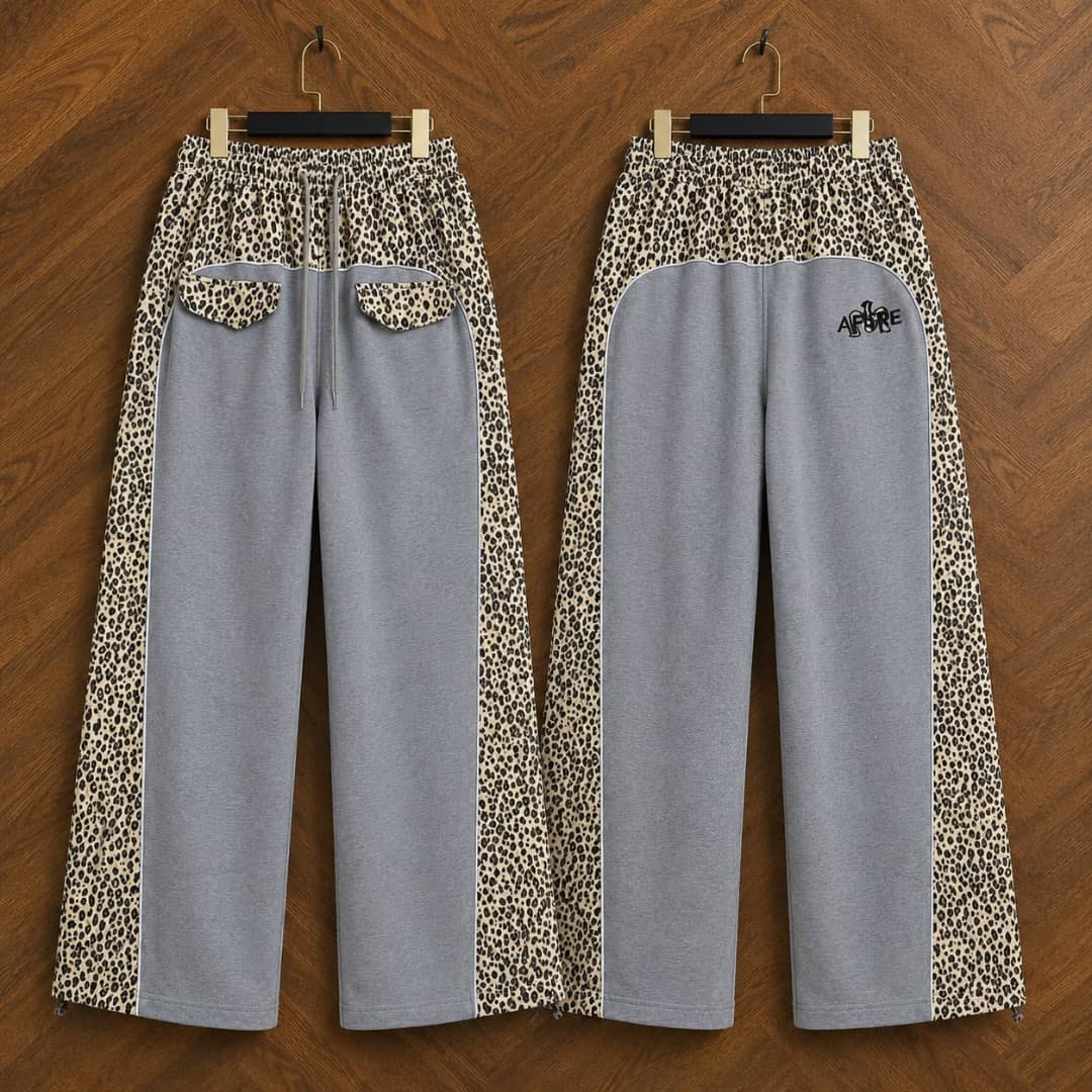 Gray AFRORE leopard print joggers hanging on wooden background, front and back views.
