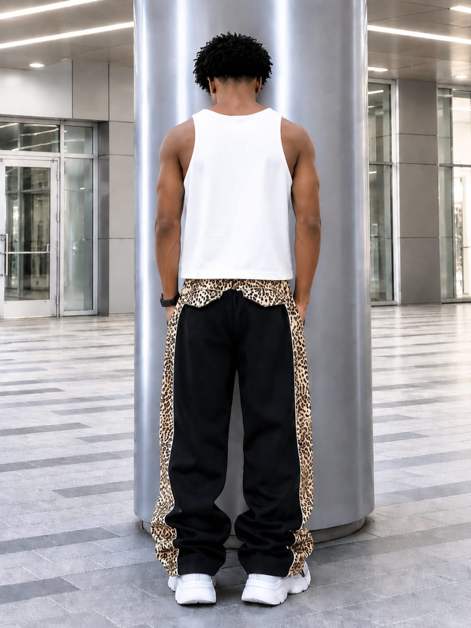 Model viewed from back wearing black AFRORE joggers with leopard print sides and waistband.