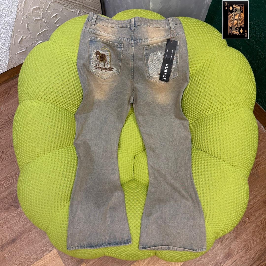Back view of gray baggy jeans with animal embroidery on pocket displayed on green ottoman.