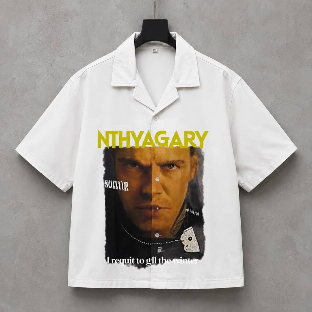 White short sleeve button-up shirt with yellow NTHYAGARY text and intense split man portrait print, displayed on hanger against gray wall.