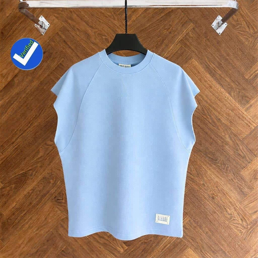 Light blue armless raglan top on black hanger against wooden floor.