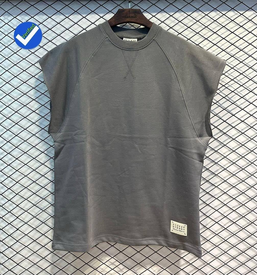 Gray armless raglan top on wooden hanger against wire grid background.