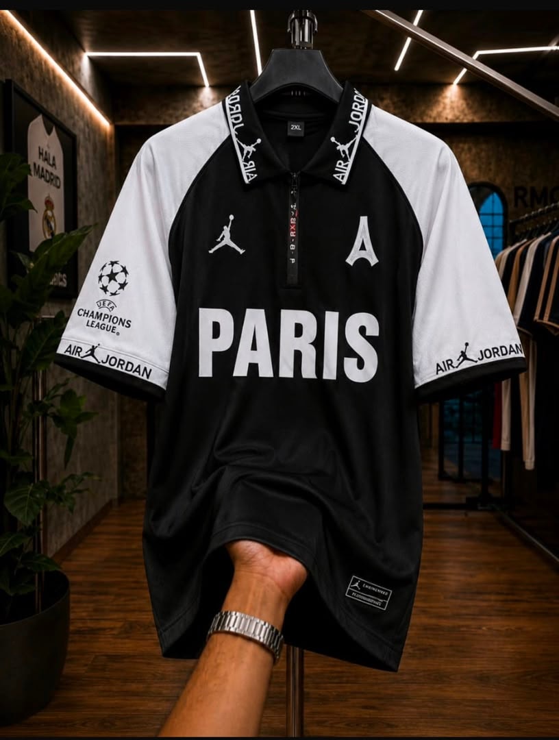 Black and white Air Jordan PSG Paris polo football jersey held by hand.