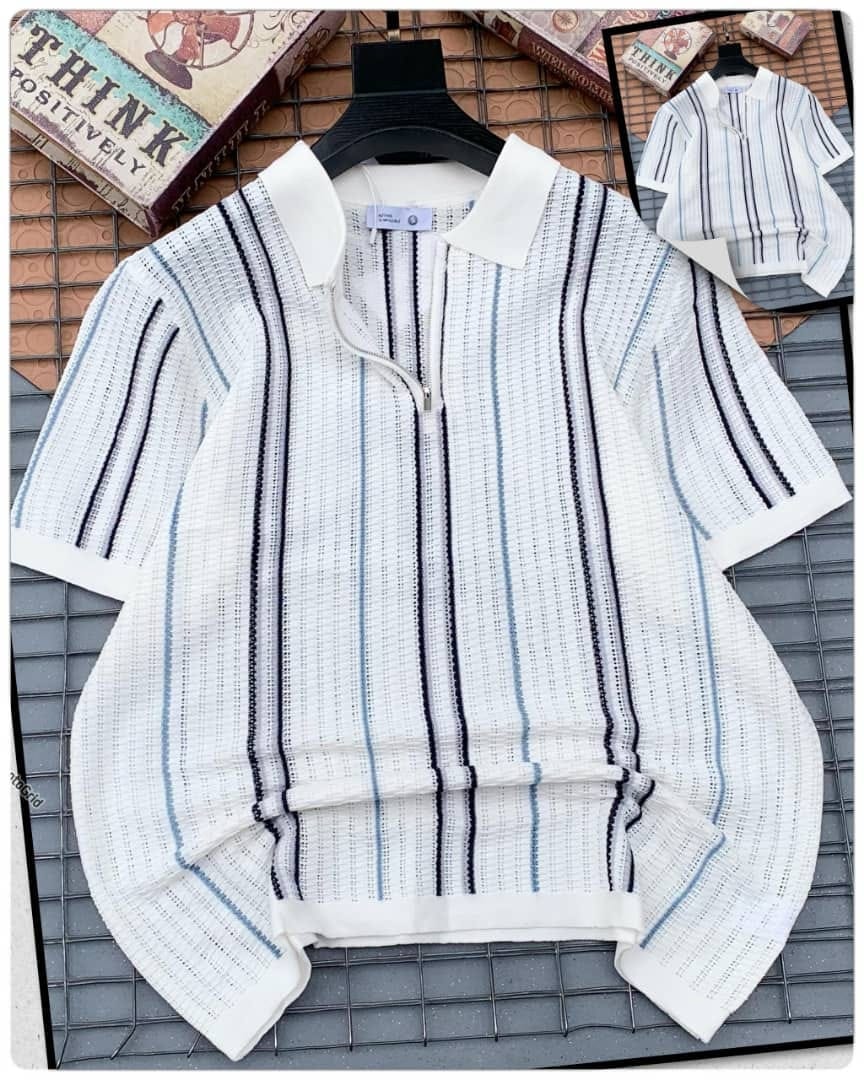 White striped knitted zip polo shirt displayed on hanger.